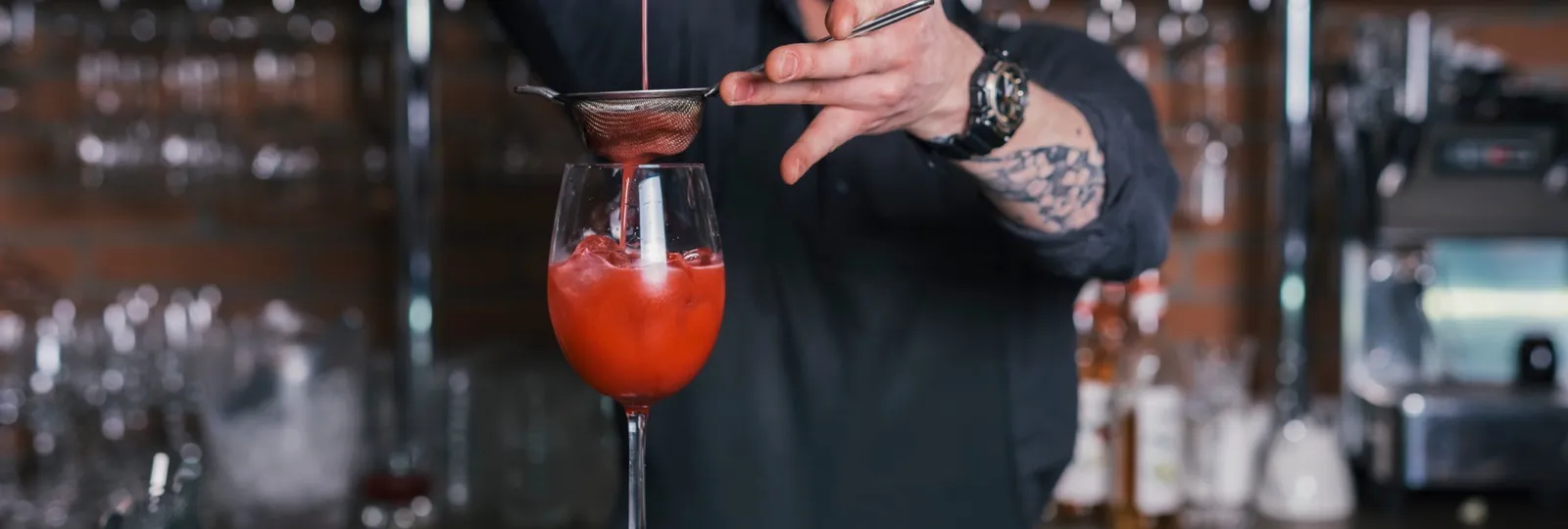 Bartender straining a signature cocktail at the Spark mobile bar