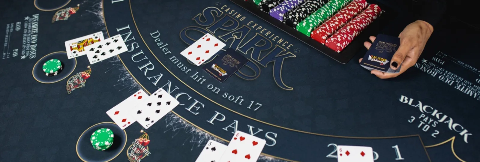 Spark dealer spreading cards on a custom Spark blackjack felt