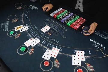 Spark dealer spreading cards on a custom blackjack felt