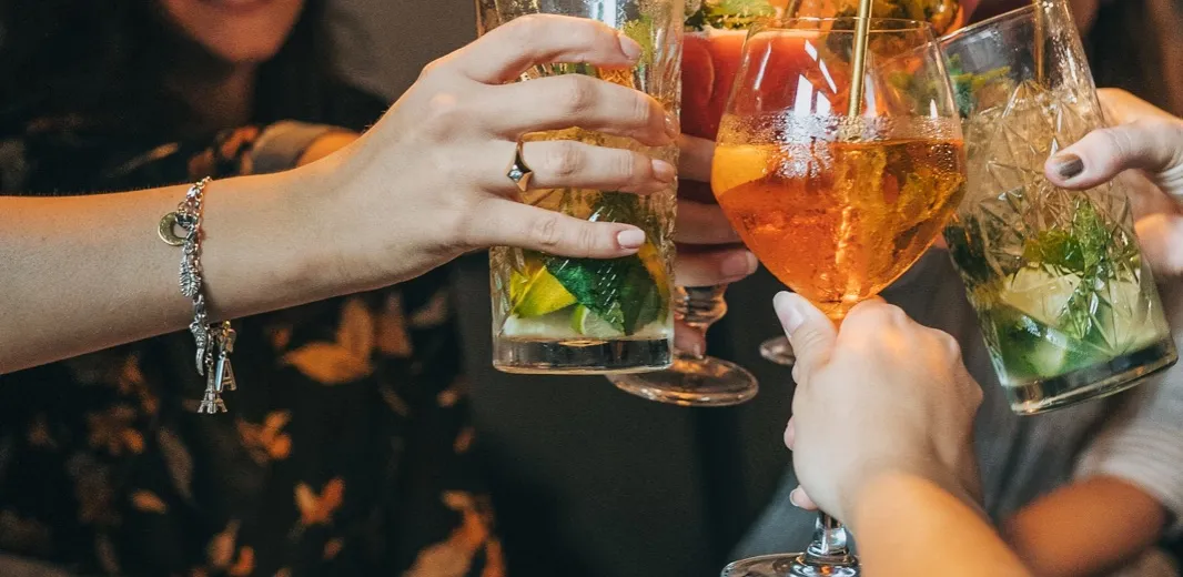 Guests raising cocktails in a toast at a Spark event