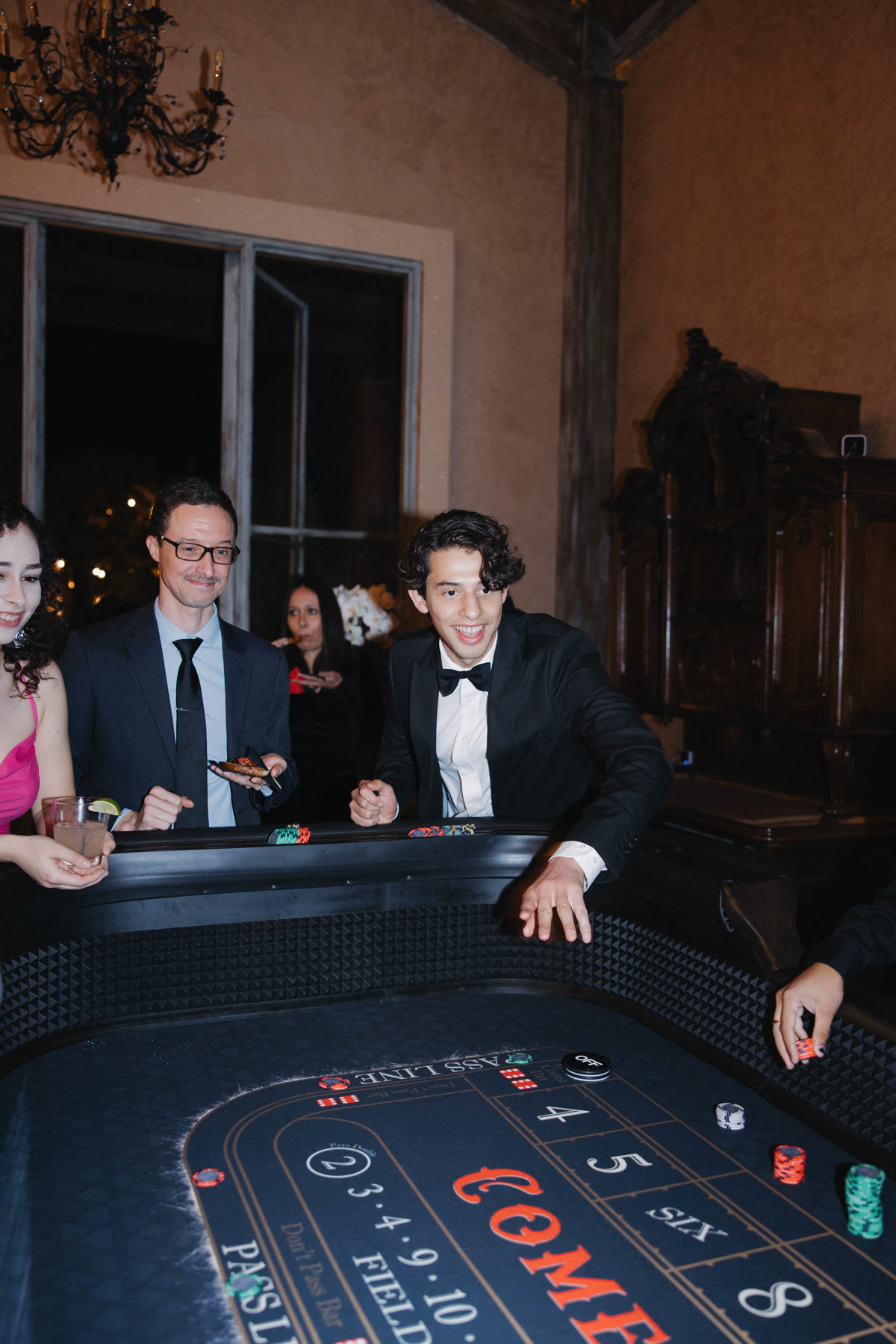 Couple playing craps together at a Spark wedding reception casino lounge